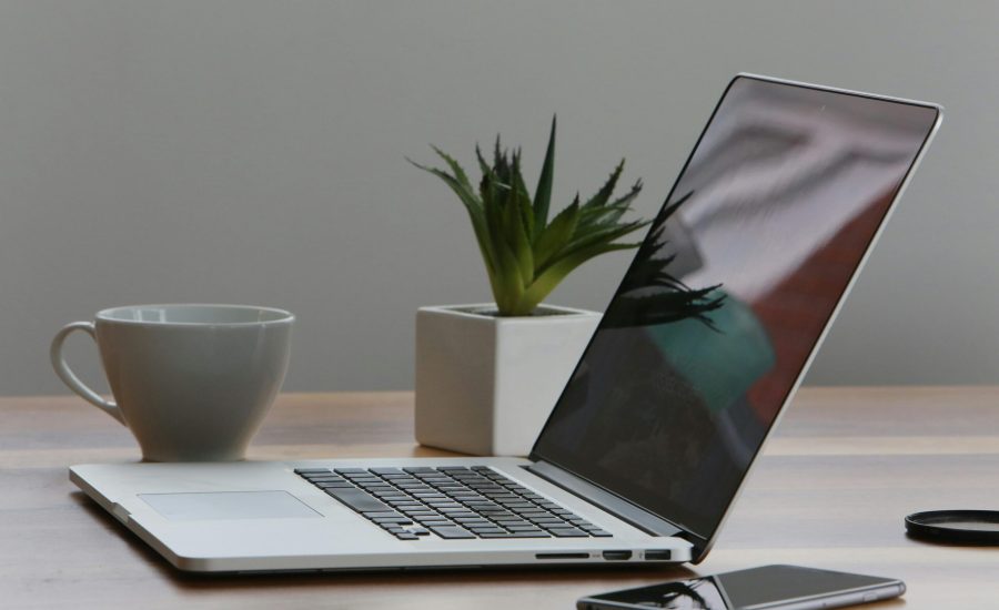Free Minimalist home office desk with laptop, smartphone, and plant for a modern work environment. Stock Photo