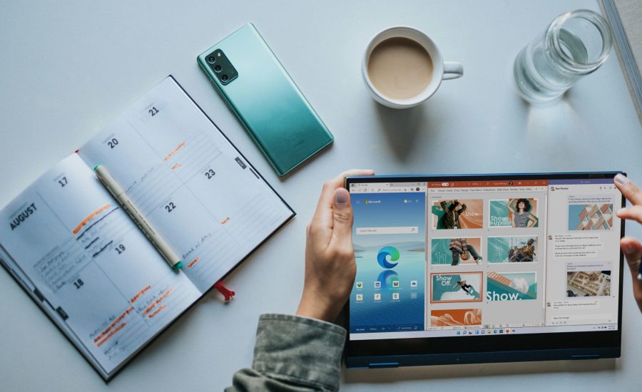 person using Windows 11 computer beside white ceramic mug on white table