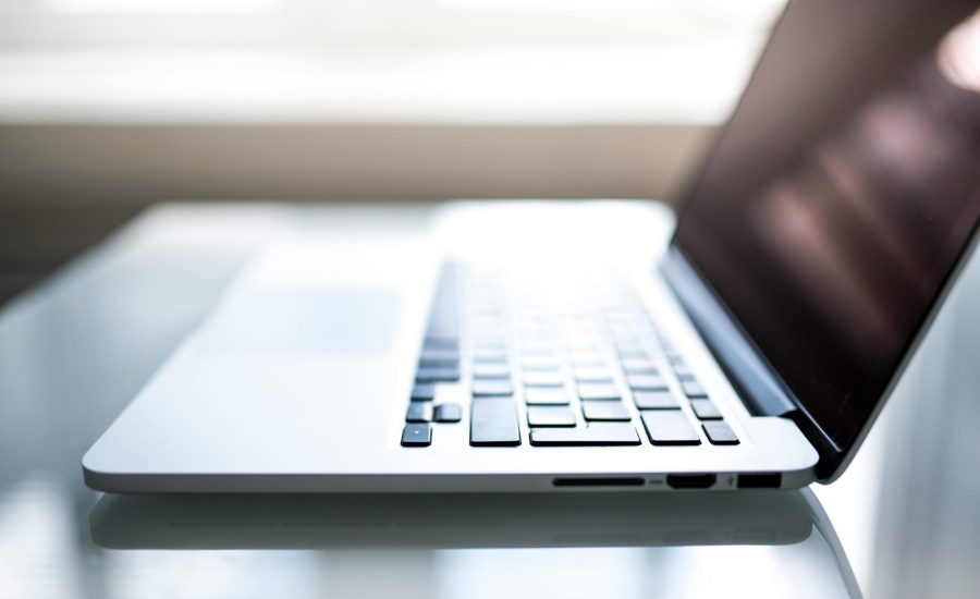 Free Elegant side view of a laptop on a glossy table with natural lighting indoors. Stock Photo