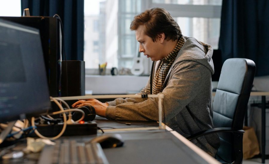 Free A concentrated professional working at a computer in a modern office setting. Stock Photo