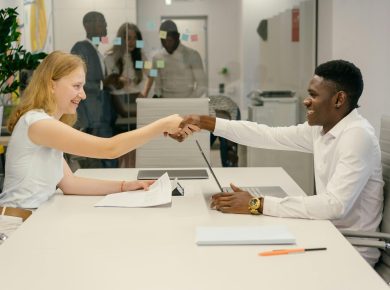 Free Business professionals completing a successful deal with a handshake in a modern office setting. Stock Photo